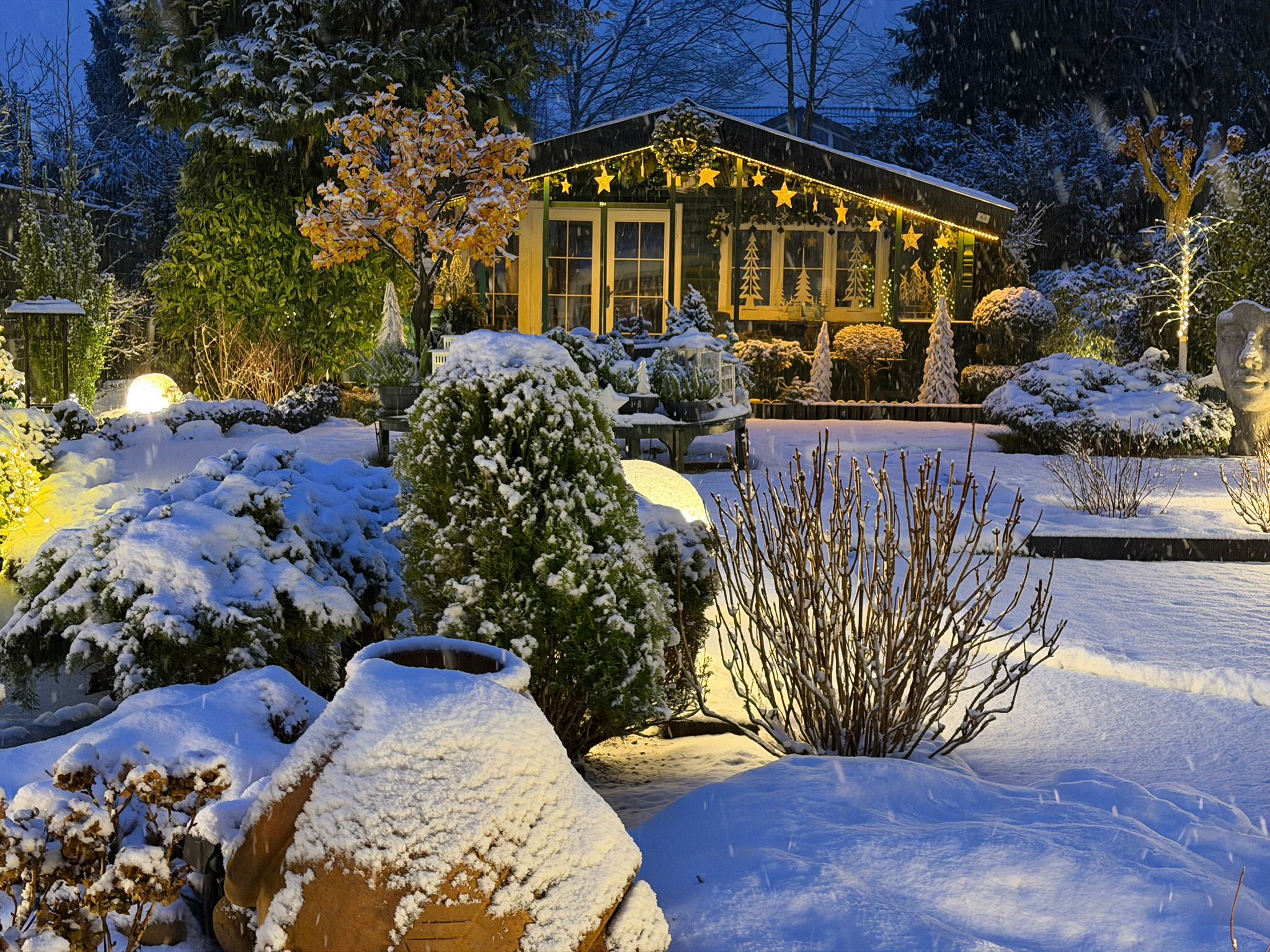GAIDT-Blockhaus beleuchtet in einem verschneiten Garten